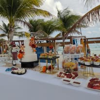 Mesa de dulces y bocadillos en evento en la playa