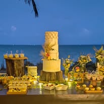 Mesa de postres iluminada frente al mar